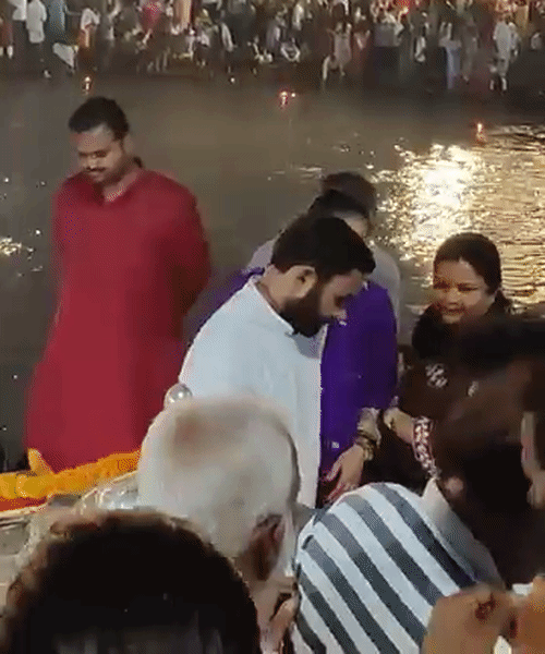 गंगा घाटावर लोक सायनासोबत सेल्फी घेताना.