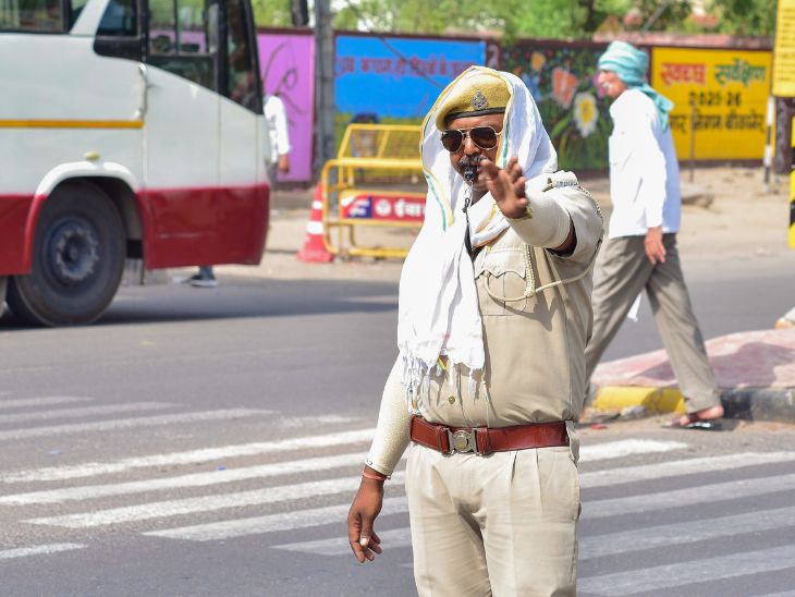 बीकानेर में गर्मी से बचने के लिए ट्रैफिक पुलिसकर्मी गमछा से चेहरा ढककर ड्यूटी करता दिखा।