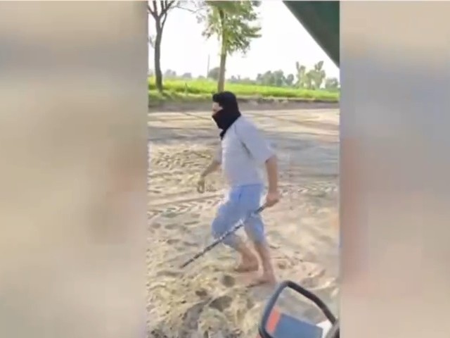 हाथ में डंडा लेकर आरोपी की फोटो।