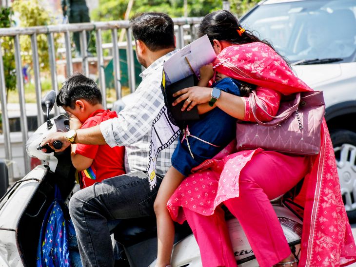 प्रयागराज में हीटवेव के कारण स्कूटी पर सवार बच्चे अपने हाथ और कपड़े से चेहरा ढकते दिखे।