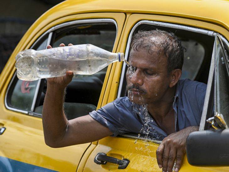 कोलकाता में एक टैक्सी ड्राइवर गर्मी से राहत पाने के लिए चेहरे पर पानी डालता दिखा।