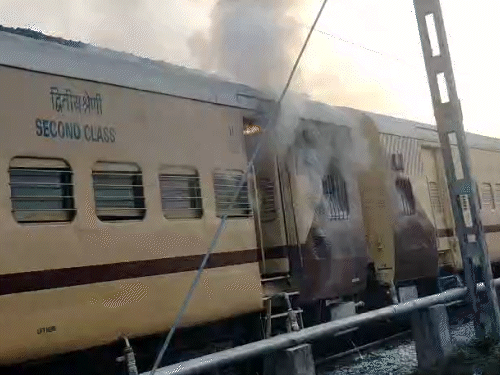 ट्रेन में आग लगने के बाद यात्री सामान छोड़कर ट्रेन से भाग निकले।