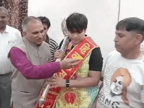 काजल के पिता को मिठाई खिलाते सोनीपत मेयर राजीव जैन