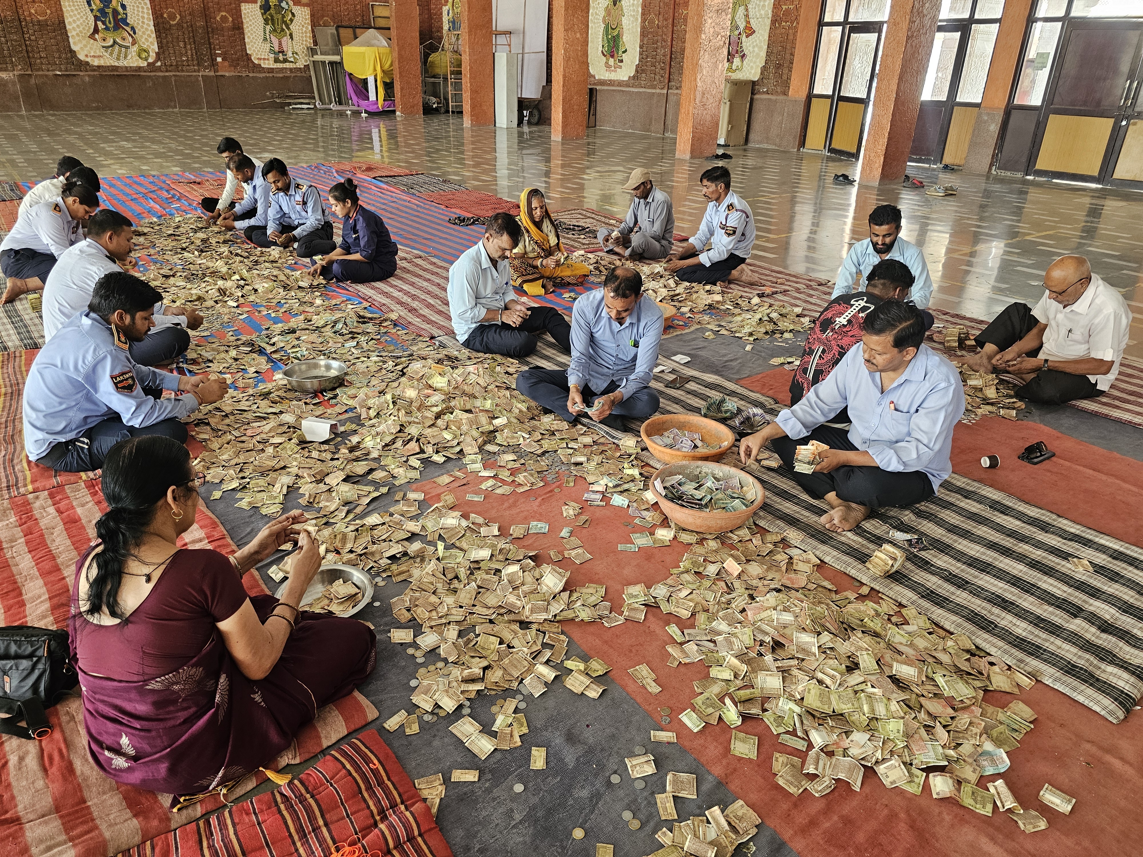 मंदिर परिसर में फर्स पर दान पात्रों को खाली किया गया।