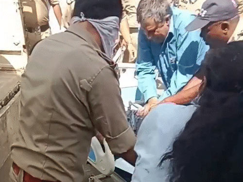 मरीज को बाहर निकाल उसे सीपीआर देते पुलिसकर्मी और डॉक्टर।