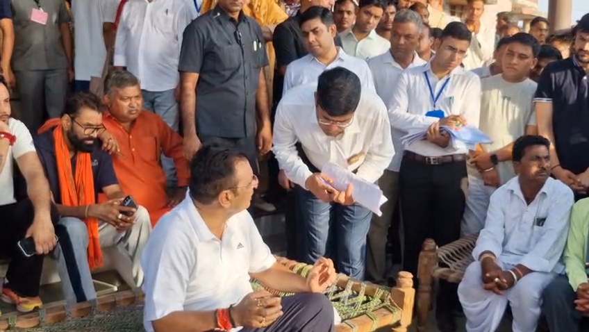 मुख्यमंत्री खांट पर बैठकर ग्रामीणों से संवाद के दौरान जिला कलेक्टर को निर्देश देते हुए।
