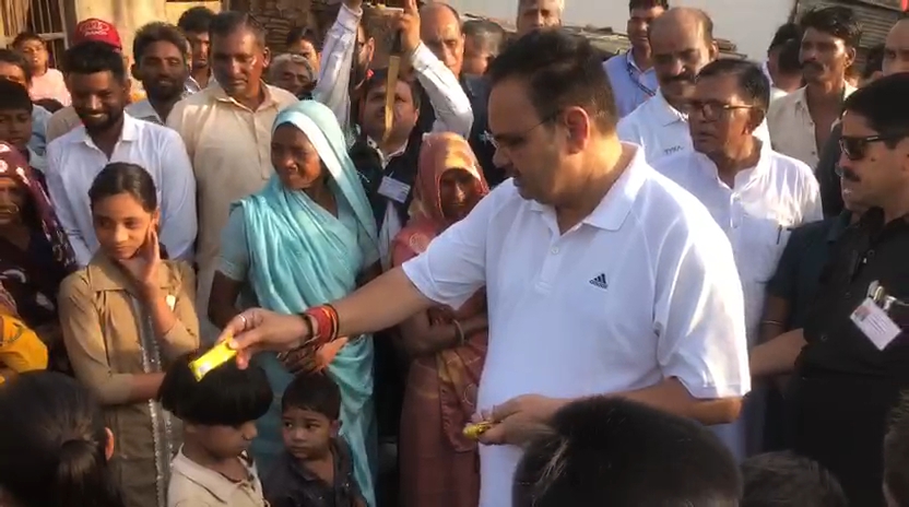 बच्चों को चॉकलेट बांटते हुए।