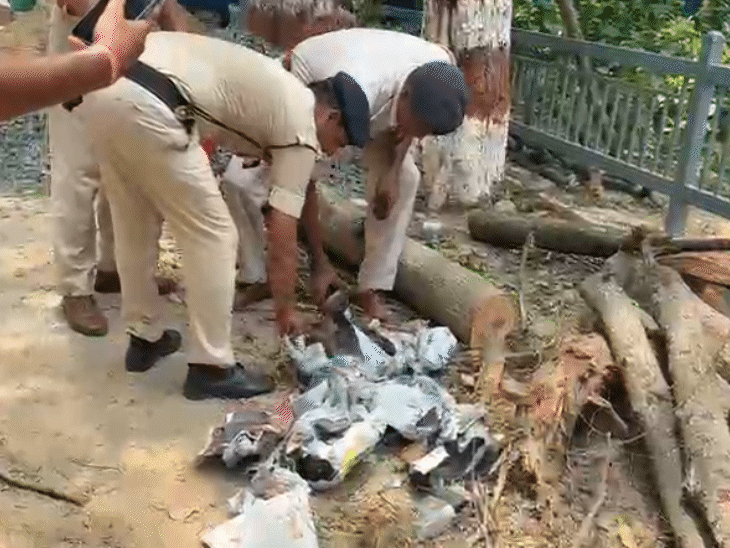 शराब की बोतलों को उठाकर थैले में रखती पुलिस।