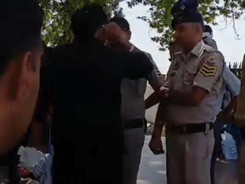 रिज पर हुक्का पी रहे टूरिस्ट को ऐसा करने से रोकते हुए पुलिस।