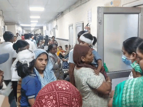 बच्चों को गोद में लेकर जांच कराते हुए अभिभावक।