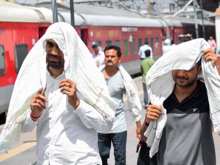 प्रयागराज रेलवे स्टेशन पर यात्री खुद को गर्मी से बचाने के लिए गमछा (पारंपरिक भारतीय तौलिये) से ढंकते नजर आए।