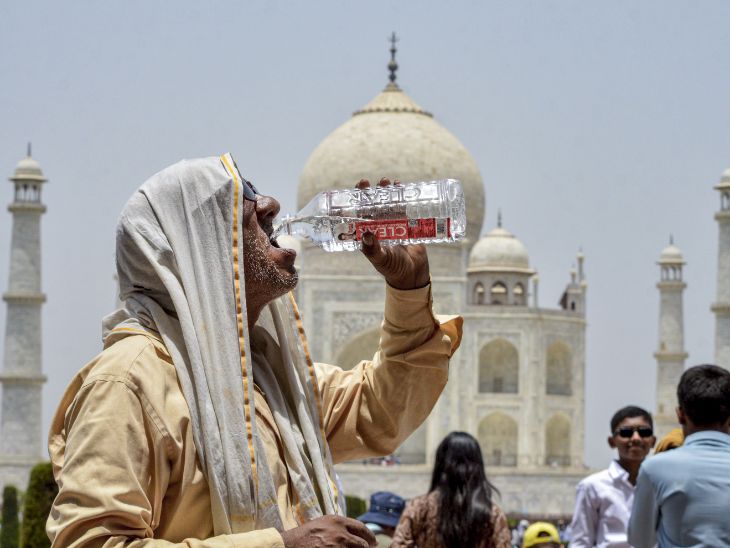 आगरा के ताज महल में एक बुजुर्ग पर्यटक गर्मी के बीच पानी पीते नजर आए