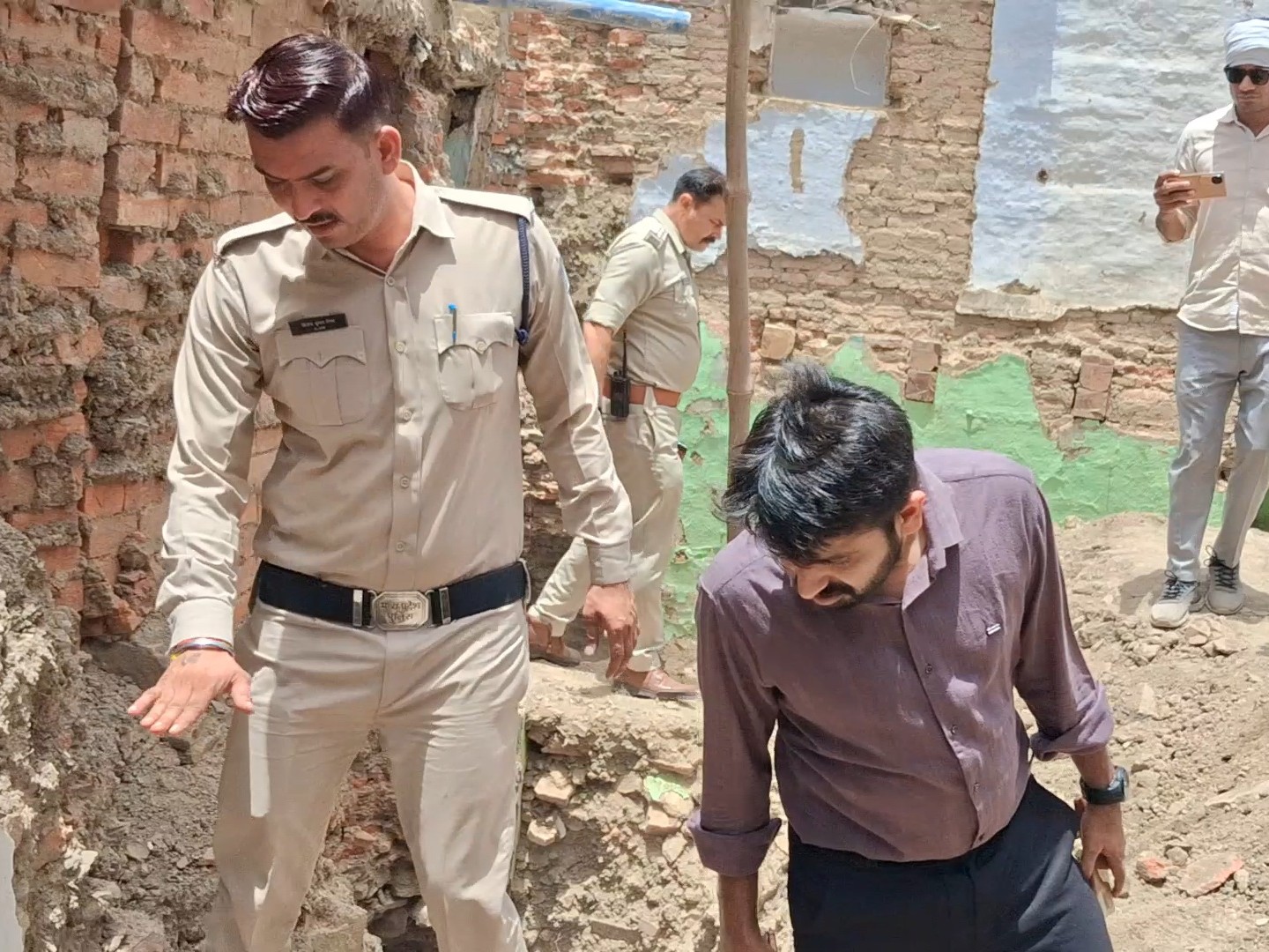 सिक्के मिलने वाली जगह का निरीक्षण करते पुलिस और पुरातत्व विभाग के अधिकारी।
