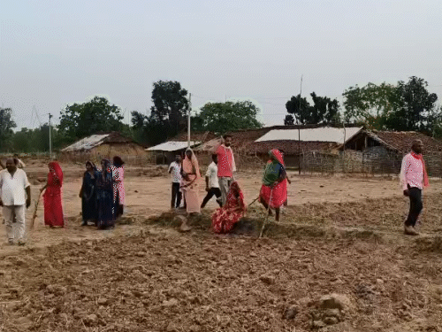 हमले के बाद लाठी लेकर निगरानी करती महिलाएं।