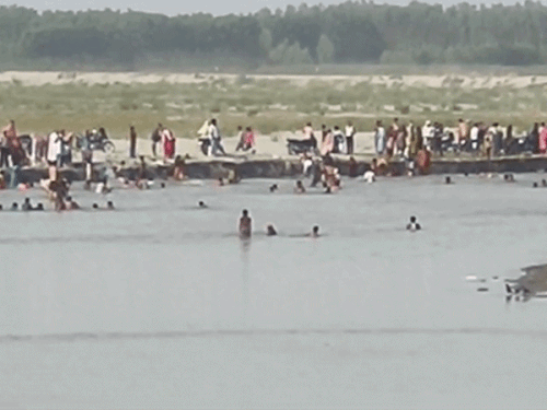 यमुना में स्नान करते लोग व यमुना में तीनों युवकों की तलाश करते ग्रामीण।