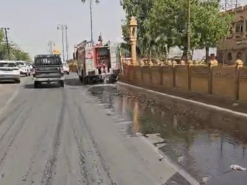 शहर में गर्मी से बचाव के लिए सड़क पर फायर ब्रिगेड से पानी का छिड़काव किया जा रहा है।