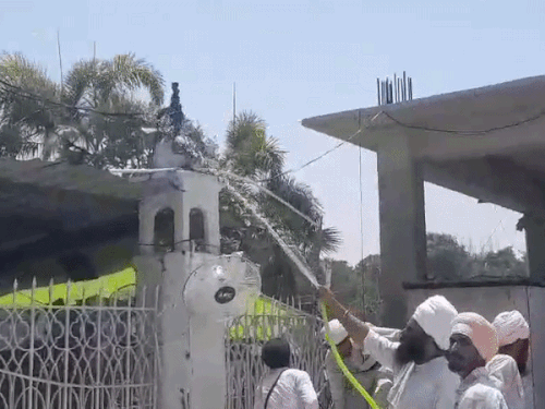 पाइपों से पानी डालकर आग बुझाने में जुटे सेवादार।