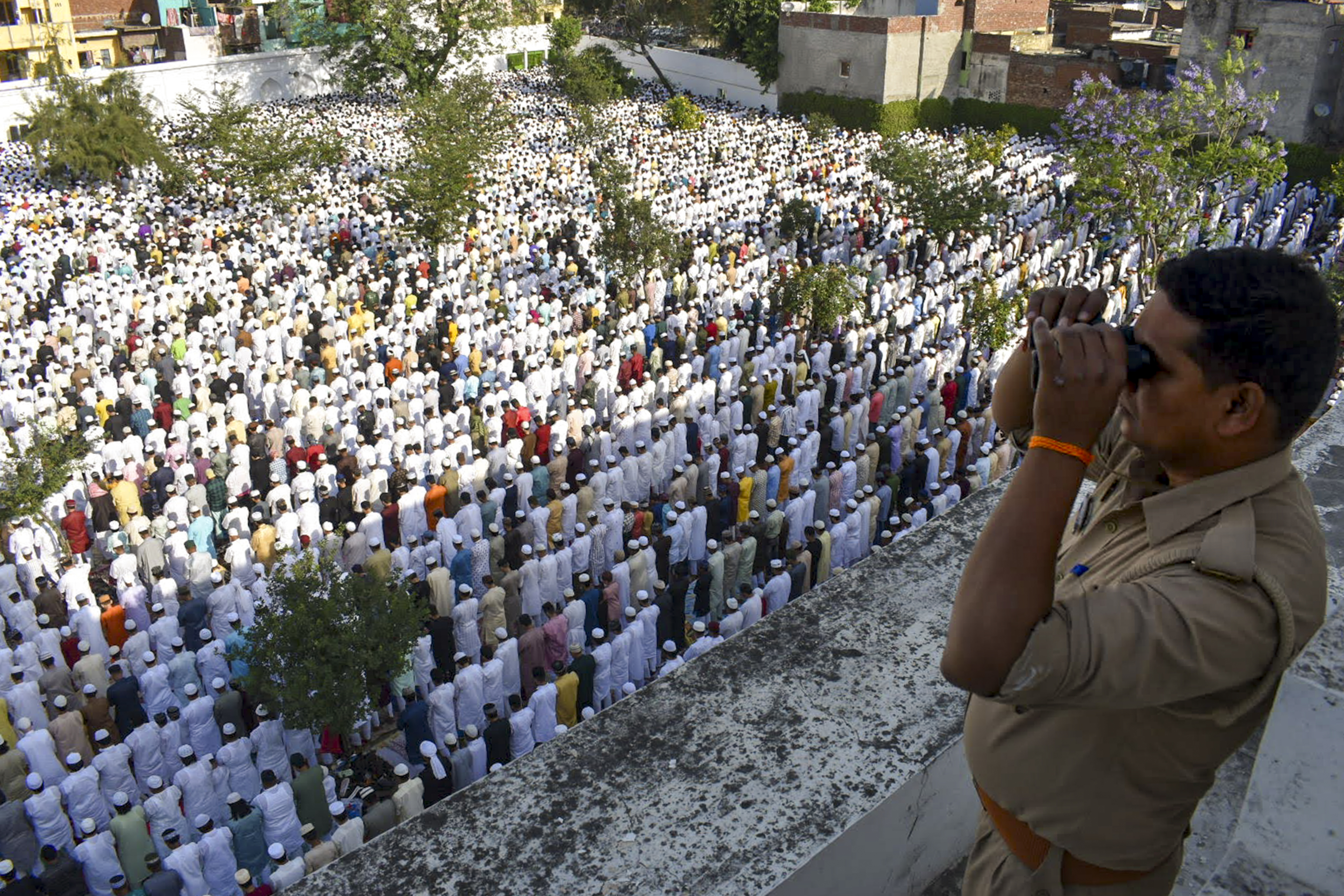 उत्तर प्रदेश के मेरठ में शाही ईदगाह पर लोग ईद-उल-अजहा की नमाज अदा कर रहे हैं, जबकि एक पुलिसकर्मी निगरानी कर रहा है।