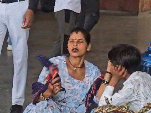 सोनीपत में पंखा न होने पर डुपट्टे से हवा करती महिला।