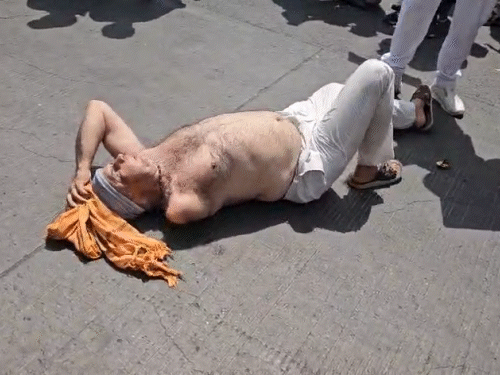 एक अर्धनग्न किसान सड़क पर लोट रहा है.