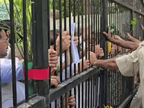 इनेलो कार्यकताओं और पदाधिकारी गेट को धक्का लगाते हुए और पुलिस रोकने की कोशिश करते हुए