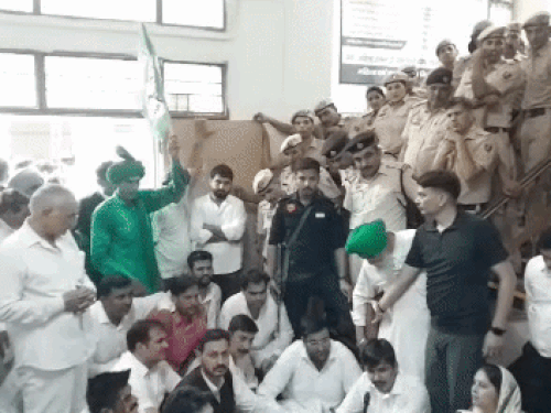 डीसी ऑफिस में सीढ़ियों के पास बैठे हुए इनेलो कार्यकर्ता।