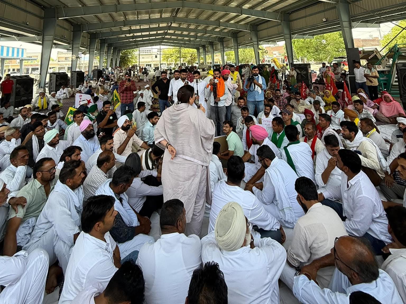 डबवाली अनाज मंडी में महापंचायत में मौजूद किसान नेता व अन्य लोग और संबोधित करती संतोष बैनिवाल