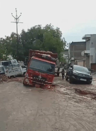 यूपी के आगरा में सड़कों में बड़े-बड़े गड्‌ढे बन जाने की वजह से ट्रक और कारें उसमें पलट गईं।