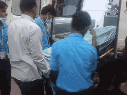 क्रेन पलटने से मृत मजदूरों के शवों को ले जाते स्वास्थ्य कर्मचारी।