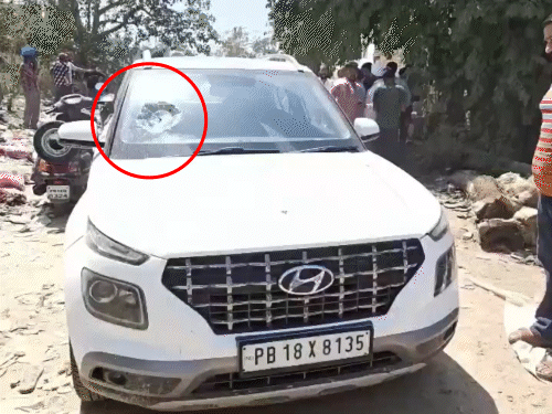 कार का शीशा टूटा, मौके पर जांच करती हुई पुलिस।