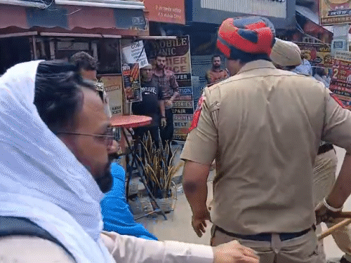 पुलिस ने धक्के मारकर प्रदर्शनकारी को जमीन पर गिरा दिया।