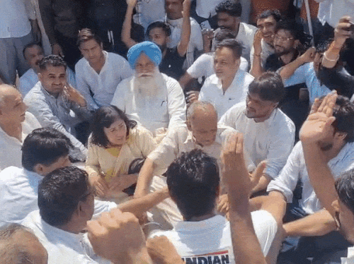हिरासत में लिए जाने के बाद सड़क पर बैठ कर प्रदर्शन करते दीपेंद्र हुड्‌डा और अन्य नेता।