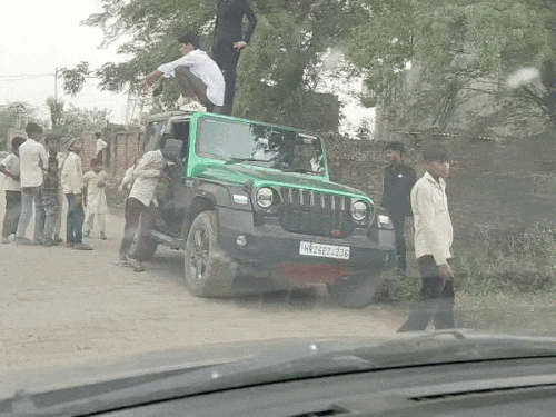 थार गाड़ी की छत पर चढ़ते बाराती।