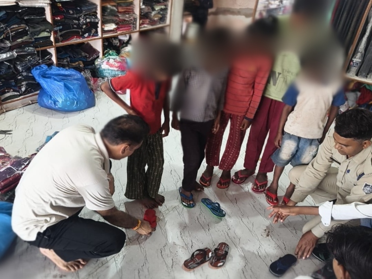 बच्चों को अपने हाथों से चप्पल पहनाते हुए घाटीगांव थाना प्रभारी पूरन शर्मा। - Dainik Bhaskar