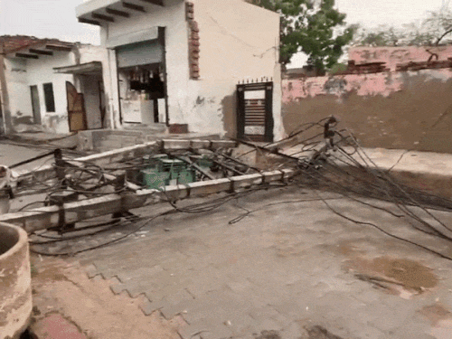 रेवाड़ी के गांव कालड़ावास में पोल टूटने से गली में पड़ा ट्रांसफार्मर।