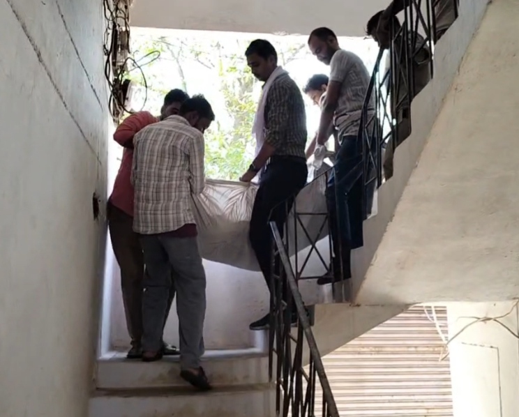 पुलिसकर्मी शव को अस्पताल ले जा रहे हैं