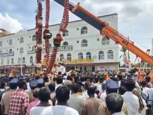 सेब की माला को क्रेन की मदद से उठाया गया।