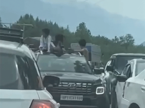 खिड़की से बाहर लटके बच्चे।