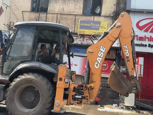 जेसीबी से दुकान के सामने का हिस्सा तोड़ा गया।