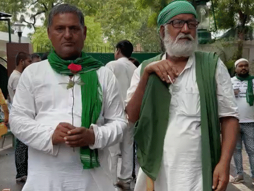 राबड़ी आवास के बाहर गुलाब का फूल लेकर खड़े कार्यकर्ता।
