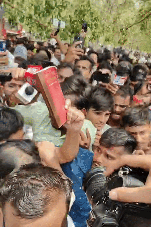 अभिजीत दीपके ने हाथ में संविधान की किताब ले रखी है। उन्होंने किताब दिखाकर प्रदर्शन कर रहे अपने समर्थकों का अभिवादन किया।