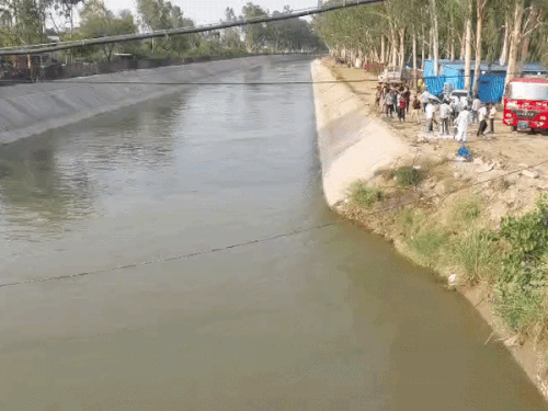 लड़के के नहर में छलांग लगाने के बाद मौके पर जमा लोगों की भीड़।