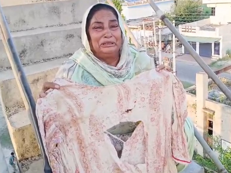 फटे कपड़े दिखाती हुई महिला।