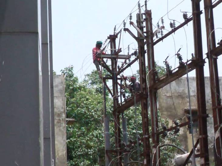 मरम्मत कार्य करते बिजली कर्मचारी।