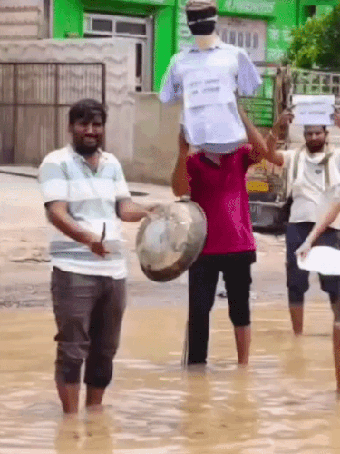सड़क पर भरे पानी में खड़े होकर परात बजाकर प्रदर्शन किया।