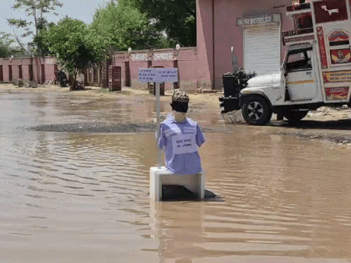 सड़क पर रखे गए पुतलों के जरिए प्रशासन पर तंज कसा।