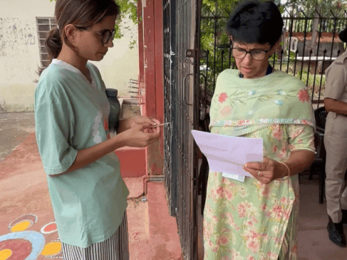 परीक्षा केंद्र में प्रवेश देने से पहले एडमिट कार्ड की जांच करते हुए केंद्र स्टाफ।