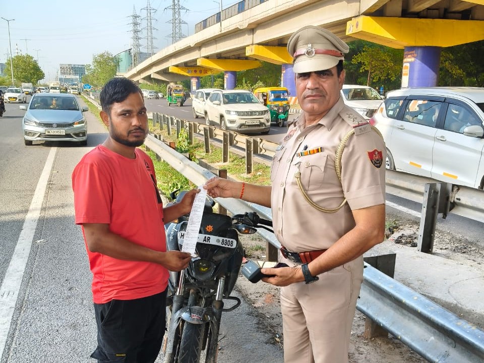 बाइक चालक को ट्रैफिक पुलिस अधिकारी चालान की रसीद देते हुए। - Dainik Bhaskar