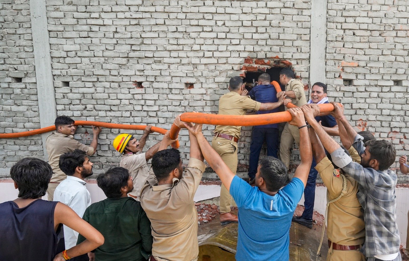 पुलिस और फायर ब्रिगेड कर्मियों ने दीवार के टूटे हुए हिस्से से पानी डालकर आग पर काबू पाया।