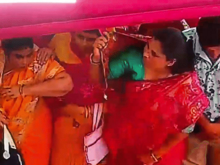 वीडियो में दिख रहा है कि आगे और पीछे की महिलाएं लगातार बीच वाली महिला की गर्दन तक पहुंच रही हैं.